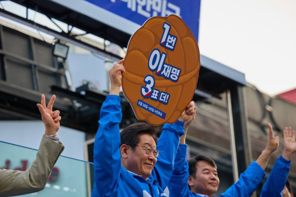 이재명 더불어민주당 대선 후보가 2025년 5월 25일 충남 천안시 신부문화거리에서 지지를 호소하며 호두과자 모형의 피켓을 들어보이고 있다. ⓒ 더불어민주당