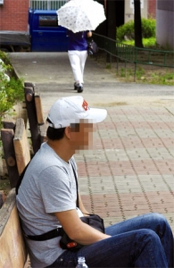 고동석(가명)씨가 경기경찰청 앞 집회 현장 부근 벤치에 앉아 있다.