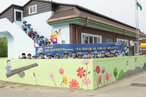 지난 23일 봉사활동에 참가한 봉사자들이 자신들이 그린 벽화 앞에서 기념촬영에 임하고 있다.(사진제공=현대제철)