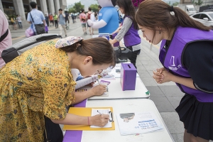 6월 24일 세종문화회관 앞. 문재인 대통령에게 보내는 양심수 석방을 위한 보라색 엽서를 쓰고 있는 시민, 엽서를 받는 청년이 간절하게 손을 모아 그 모습을 지켜보고 있다. 청와대에 전달된 양심수 석방 국민청원에는 1만 6,650명의 국민이 서명했다.